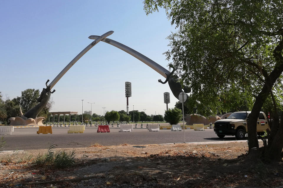 Iraqi security forces patrol by the crossed swords monument in Baghdad, Iraq, Tuesday, Sept. 24, 2019. Two rockets were fired into the capital's fortified Green Zone Monday evening, landing around one kilometer (a half-mile) from the U.S. Embassy amid soaring tensions between the U.S. and Iran. (AP Photo/Hadi Mizban)