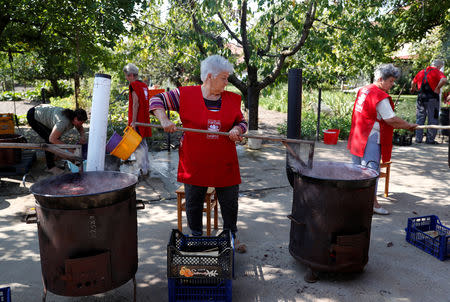 Elderly women cook plum marmalade in Bordany, Hungary, September 19, 2018. REUTERS/Bernadett Szabo