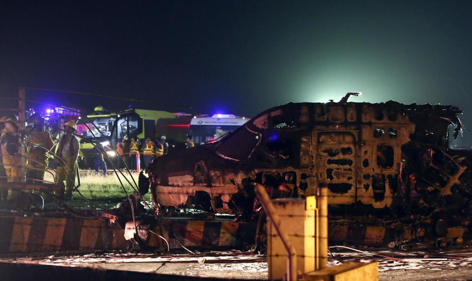 Firemen and rescuers talk beside the remains of a Lion Air, West Wind 24 aircraft after it caught fire during take off at Manila's International Airport in Philippines (AP)