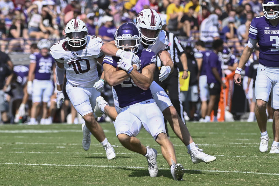 Northwestern running back Evan Hull (26) is tackled by Southern Illinois linebacker Branson Combs, right, on Saturday, Sept. 17, 2022, in Evanston, Ill. Northwestern lost 31-24. (AP Photo/Matt Marton)