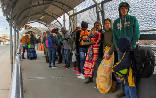 In this file photo taken on January 9, 2019 migrants from Cuba, Venezuela and Central America queue at the Paso del Norte International Bridge in Ciudad Juarez, Mexico, to cross the border and request political asylum in the United States