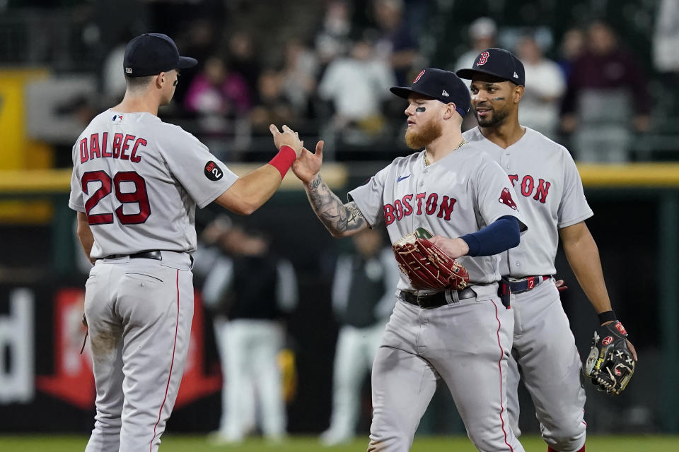 Boston Red Sox's Bobby Dalbec, Alex Verdugo and Xander Bogaerts, fromleft, celebrate the team's 16-7 win over the Chicago White Sox in a baseball game Thursday, May 26, 2022, in Chicago. (AP Photo/Charles Rex Arbogast)