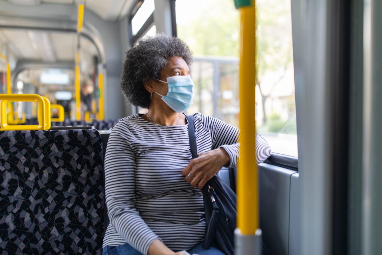 Woman wearing medical face mask commuting in a tram train during corona virus outbreak. Female travelling in metro during Covid-19 pandemic.