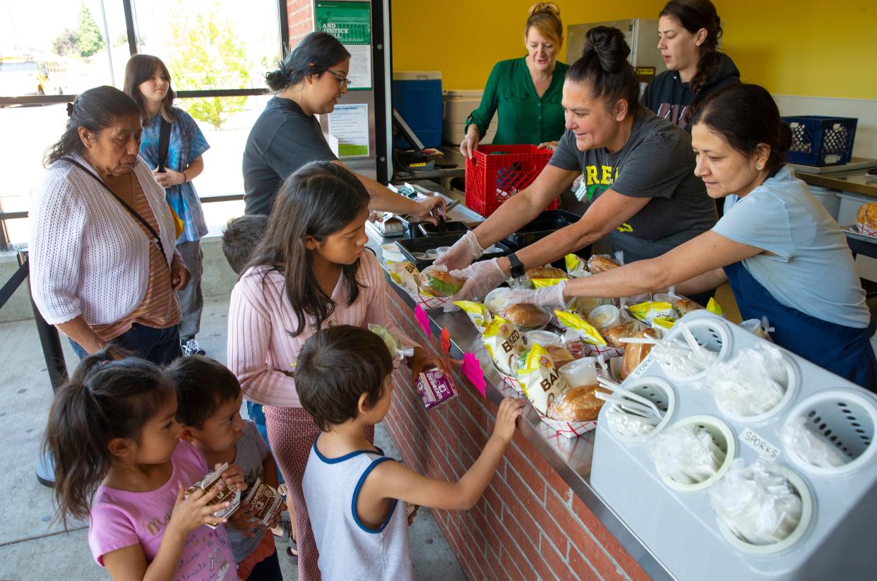 Children line up to receive a free summer meal from staff at Willamette High School in the Bethel School District.