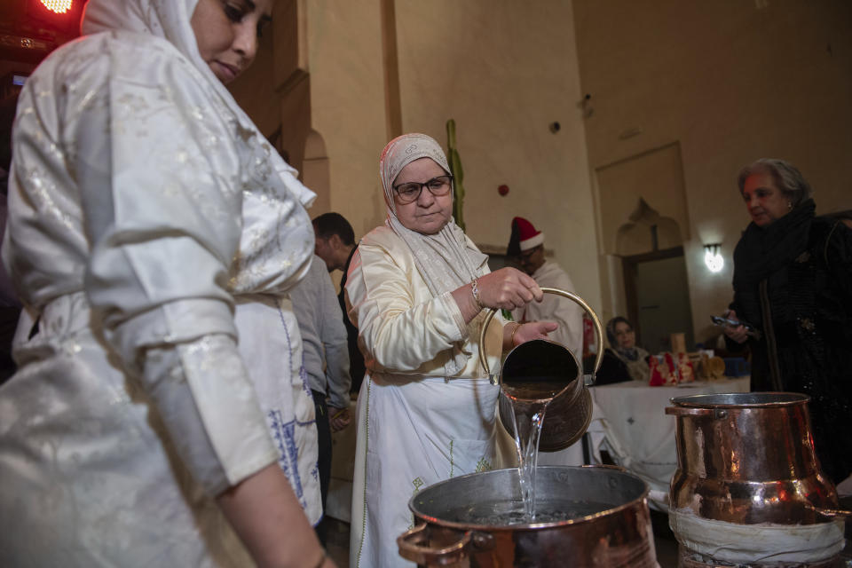 Women prepare to distill orange blossoms in a cultural center in Marrakech, Morocco, Saturday, March 23, 2024. Moroccan cities are heralding in this year's spring with orange blossoms by distilling them using traditional methods. Orange blossom water is mostly used in Moroccan pastries or mint tea and sprinkled over heads and hands in religious ceremonies. (AP Photo/Mosa'ab Elshamy)