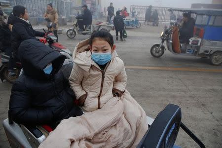 People wear face masks as heavy smog blankets Shenfang in Hebei province, on an very polluted day December 20, 2016. REUTERS/Damir Sagolj
