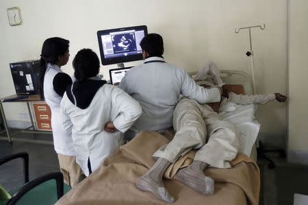 Doctors look at the ultrasound scan of a patient at Janakpuri Super Speciality Hospital in New Delhi January 19, 2015. REUTERS/Adnan Abidi/Files