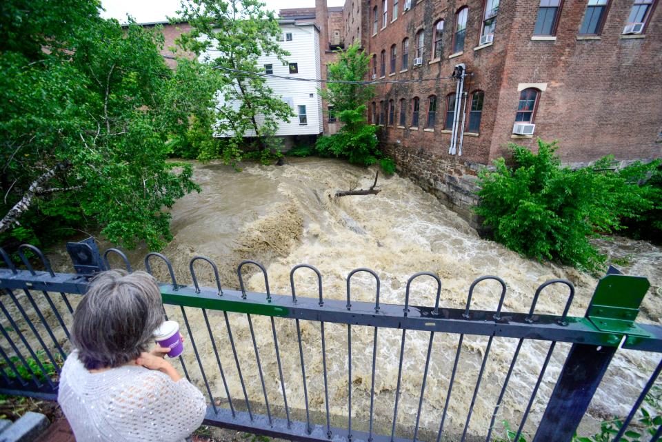 Melissa Morgan, of Northfield, Mass., looks at the water flow at the Whetstone Brook in Brattleboro, Vt., Monday, July 10, 2023. (Kristopher Radder/The Brattleboro Reformer via AP)