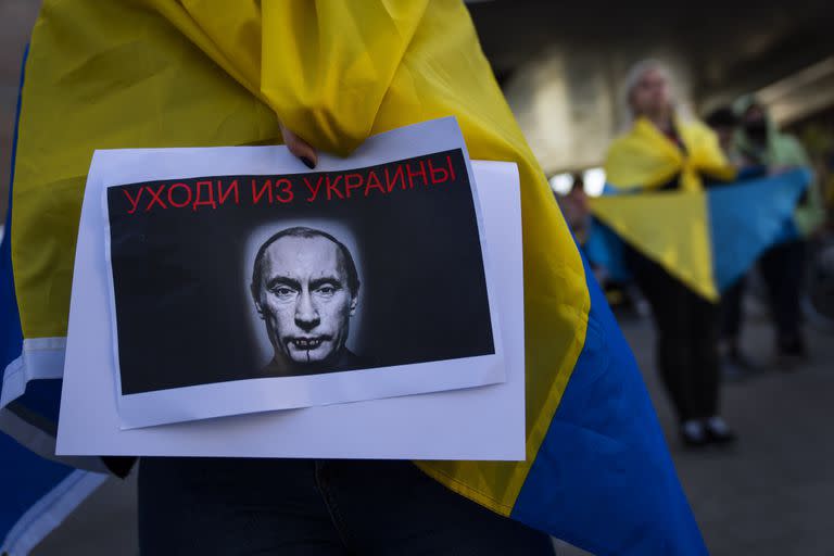 Un manifestante sostiene un cartel con la imagen del presidente ruso Vladimir Putin durante una protesta a favor de Ucrania frente a la embajada rusa 