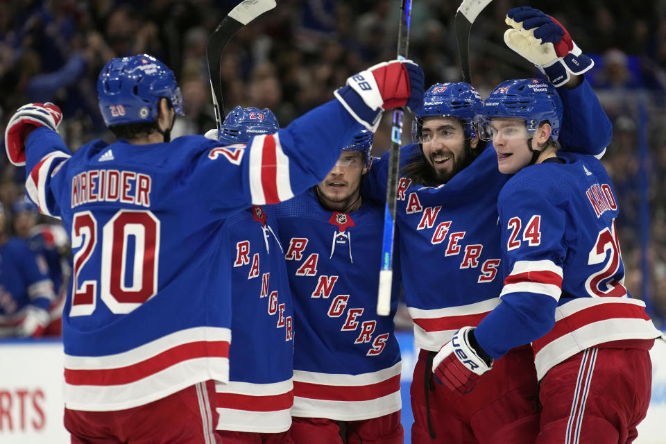 New York Rangers center Mika Zibanejad (93) celebrates his goal against the Tampa Bay Lightning with right wing Kaapo Kakko (24) and left wing Chris Kreider (20) during the first period of an NHL hockey game Thursday, Dec. 29, 2022, in Tampa, Fla. (AP Photo/Chris O'Meara)