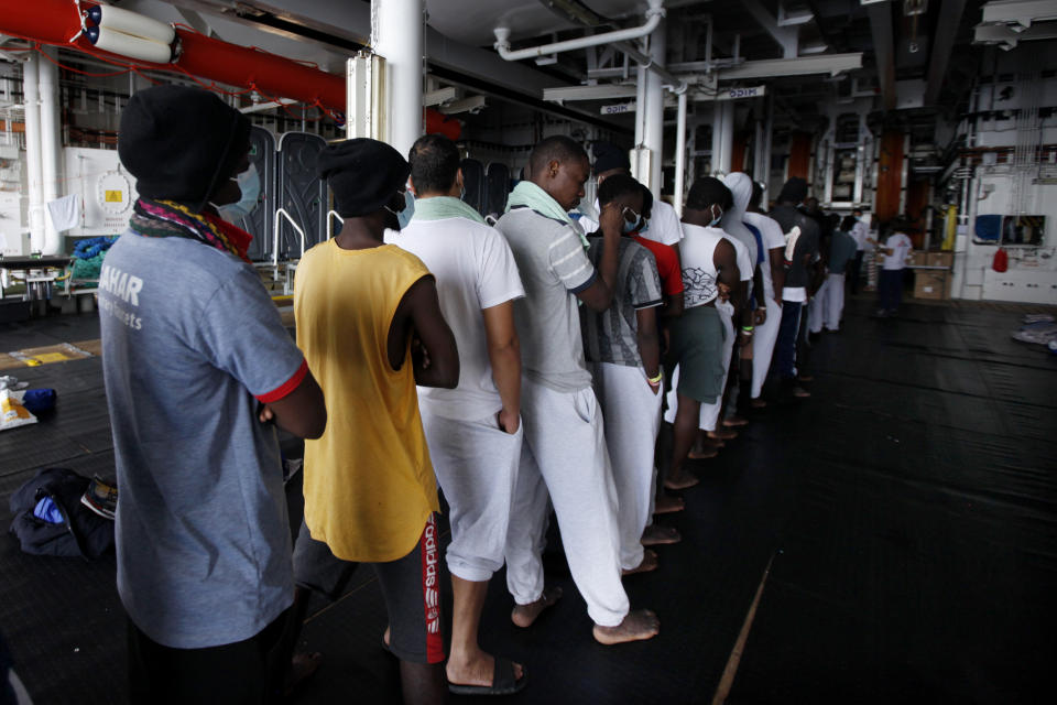 African migrants wait in line to receive meals abroad the Geo Barents vessel after they were rescued from the Mediterranean Sea off Libya, Monday, Sept. 27, 2021. Migrants say that they were tortured and their families extorted for ransoms in Libya’s detention centers. (AP Photo/Ahmed Hatem)
