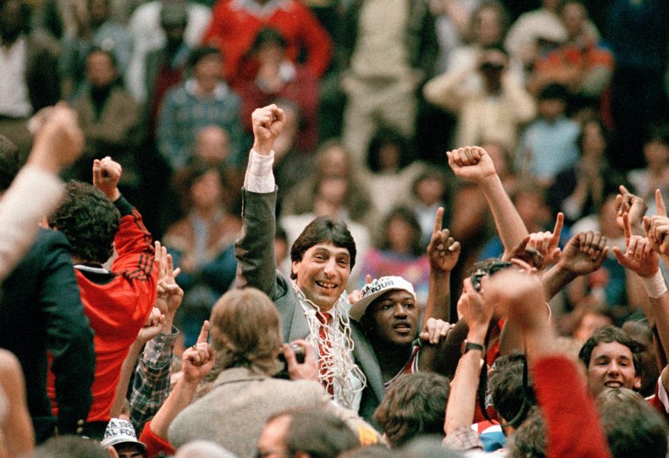 FILE - In this April 4, 1983, file photo, North Carolina State coach Jim Valvano, center with fist raised, celebrates after the team's win over Houston to win the NCAA men's basketball tournament championship in Albuquerque, N.M. This season's tournament, like all before them, would've been filled with dozens of legends in the making and diamonds in the rough _ with teams that overcame adversity to get this far and superfans who inspired the country every bit as much as their team. (AP Photo, File)