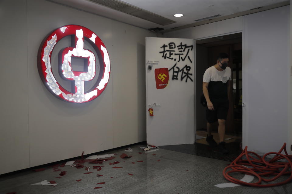 A man walks inside a Bank of China branch vandalized by protestors in Hong Kong, Sunday, Oct. 20, 2019. Hong Kong protesters flooded the city's streets on Sunday in defiance of a ban by the authorities on their march, setting up roadblocks and tossing firebombs amid the firing of tear gas by police. (AP Photo/Kin Cheung)