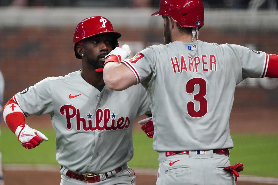 Philadelphia Phillies' Andrew McCutchen (22) celebrates with Bryce Harper (3) after hitting a solo home run in the fifth inning of a baseball game against the Atlanta Braves, Saturday, April 10, 2021, in Atlanta. (AP Photo/John Bazemore)