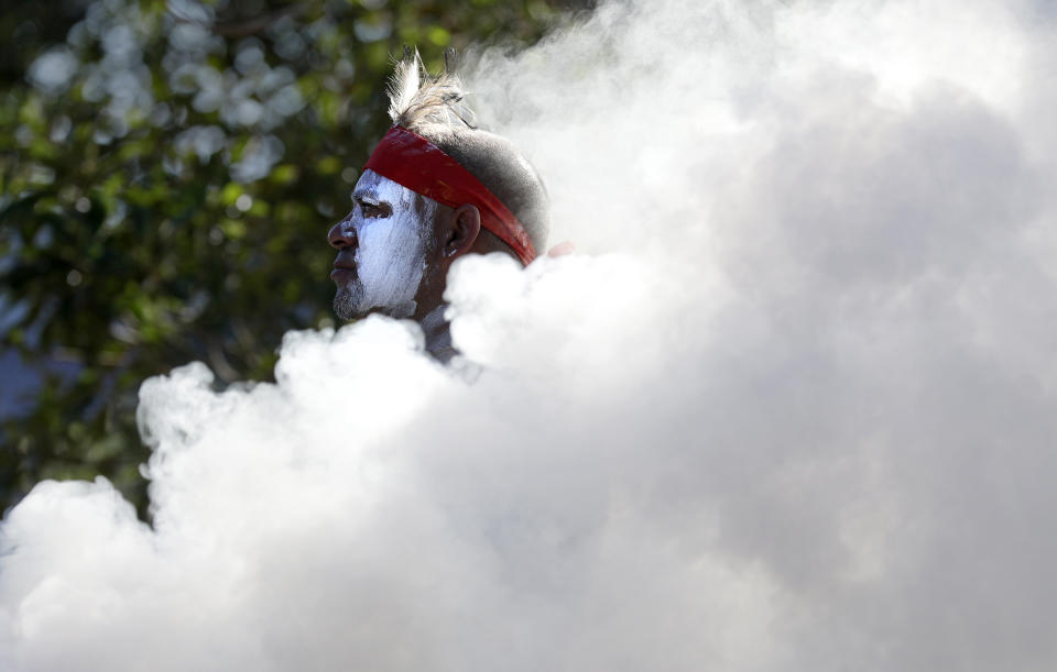 Russell Dawson of the Koomurri Aboriginal Dancers participates in a smoking ceremony during Australia Day ceremonies in Sydney, Tuesday, Jan. 26, 2021. (AP Photo/Rick Rycroft)