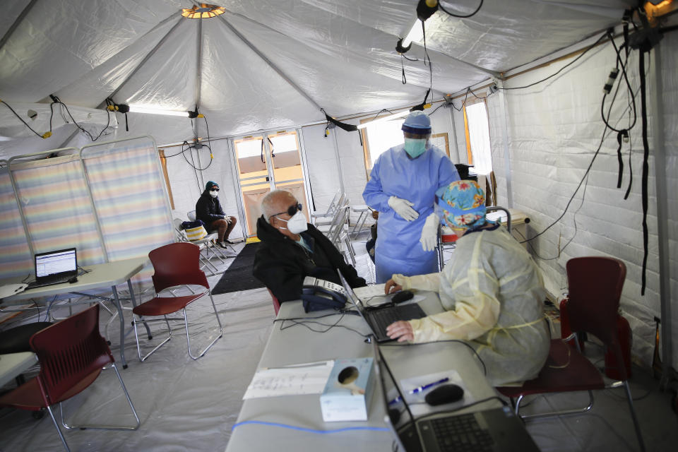 A patient waits for the results of their loved one's interview with nurses at St. Joseph's Hospital's COVID-19 testing and triage tent, Monday, April 20, 2020, in Yonkers, N.Y. (AP Photo/John Minchillo)