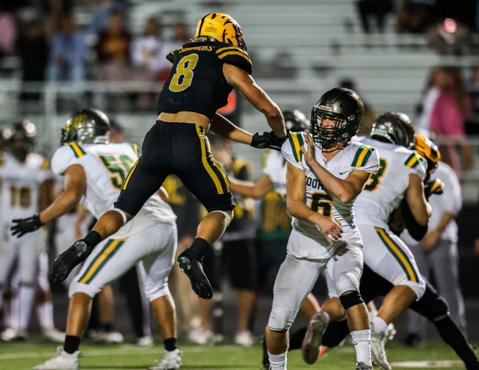 Moorpark quarterback Connor Smith gets a pass over a leaping Charlie Simmons of Newbury Park during a Canyon League game at Newbury Park High on Friday, Sept. 30, 2022. The Panthers won, 35-28.