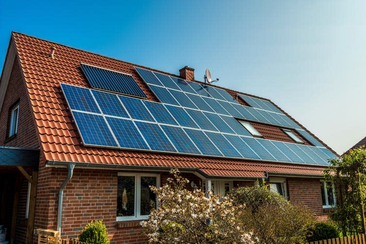 A house with a red tile roof covered in solar panels.