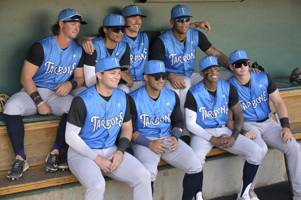 FILE - Tampa Tarpons players pose in the dugout before a minor league baseball game against the Lakeland Flying Tigers, Friday, April 8, 2022, in Lakeland, Fla. The Major League Baseball Players Association is attempting to unionize minor leaguers, reversing decades of opposition. The players' association said Monday, Aug. 29, 2022, it is circulating union authorization cards among players with minor league contracts to form a separate bargaining unit from the big leaguers. (AP Photo/Phelan M. Ebenhack, File)