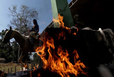 A devotee rides her horse around a chapel to make an offering to Sao Joao do Guarani (Saint Joao of Guarani) during an annual celebration in Chico Mendes Extraction Reserve in Xapuri, Acre state, Brazil, June 24, 2016. REUTERS/Ricardo Moraes