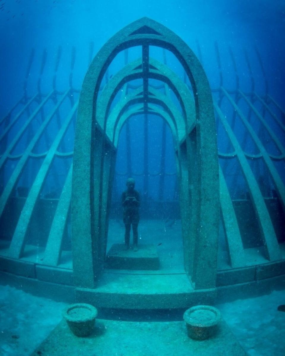 El sitio en el que se colocó la instalación fue elegido por su clara visibilidad, sus paredes de coral natural y su base plana arenosa. La estructura que rodea a las figuras consta de unas 500 piezas de acero y hormigón que se ensamblaron en cinco grandes secciones para instalarse en el fondo del océano. (Foto: Instagram / <a href="http://www.instagram.com/p/B9XzNUwpp16/" rel="nofollow noopener" target="_blank" data-ylk="slk:@moua_museum_of_underwater_art" class="link ">@moua_museum_of_underwater_art </a>/ <a href="http://www.instagram.com/matt_curnock/" rel="nofollow noopener" target="_blank" data-ylk="slk:@matt_curnock" class="link ">@matt_curnock</a>).