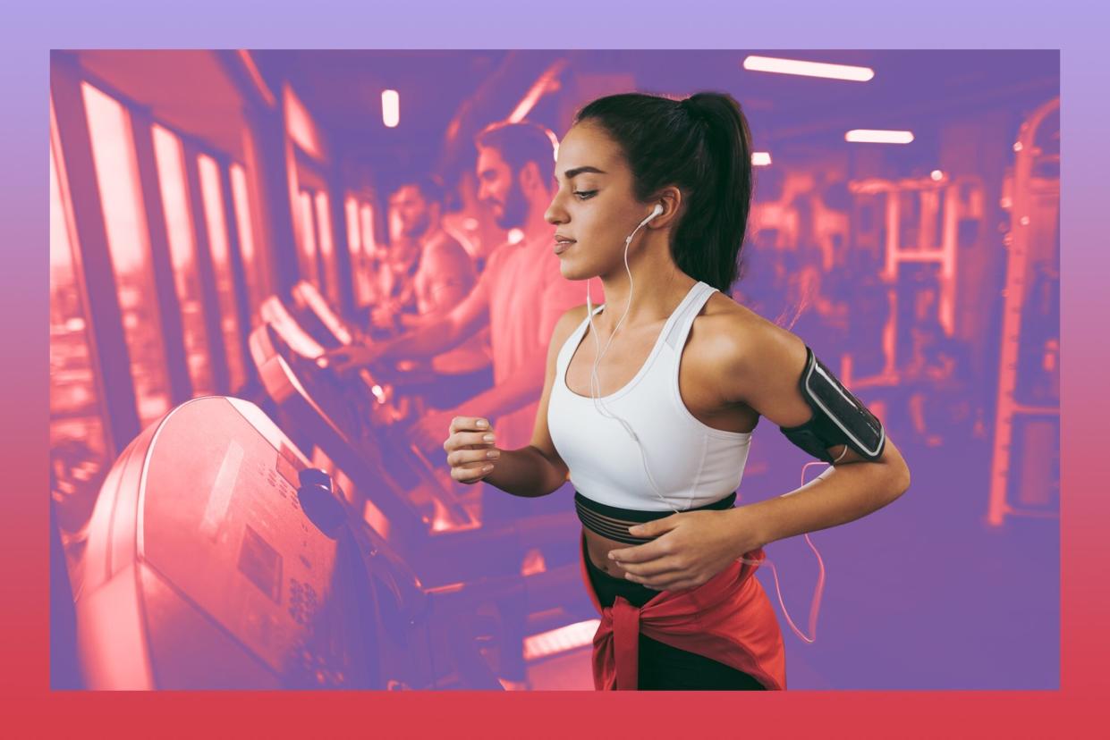 Young woman exercising on treadmill with headphones