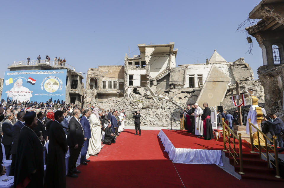 Pope Francis, surrounded by shells of destroyed churches, attends a prayer for the victims of war at Hosh al-Bieaa Church Square, in Mosul, Iraq, once the de-facto capital of IS, Sunday, March 7, 2021. The long 2014-2017 war to drive IS out left ransacked homes and charred or pulverized buildings around the north of Iraq, all sites Francis visited on Sunday. (AP Photo/Andrew Medichini)