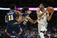 Milwaukee Bucks forward Giannis Antetokounmpo (34) is pressured by Denver Nuggets forward Zeke Nnaji (22) and guard Monte Morris (11) during the third quarter of an NBA basketball game Friday, Nov. 26, 2021, in Denver. (AP Photo/Jack Dempsey)