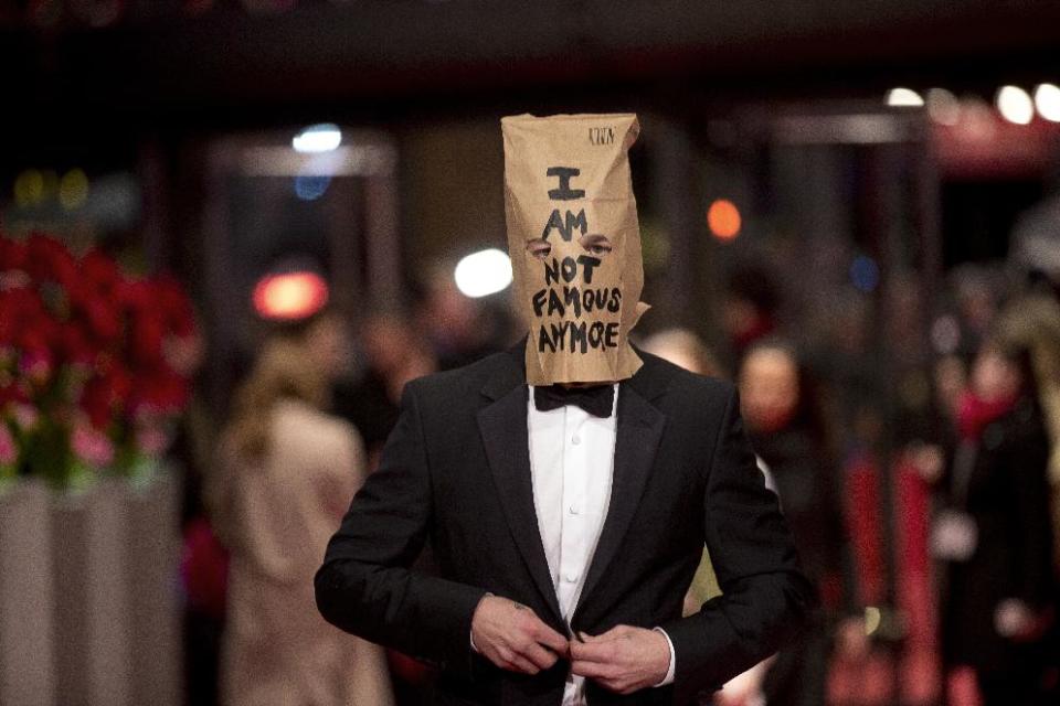 FILE - In this Sunday, Feb. 9, 2014 file photo, actor Shia LaBeouf poses for photographers on the red carpet for the film "Nymphomaniac" at the International Film Festival Berlinale, in Berlin. LaBeouf began his planned seven-hour, seven-day stint inside the Stephen Cohen Gallery in Los Angeles on Tuesday, Feb. 11, 2014, seated at a small table, wearing a disheveled tuxedo and the paper bag with some eye holes cut out and the words "I AM NOT FAMOUS ANYMORE" scrawled in black ink across it. LaBeouf's performance-art oddity comes days after he posed on the red carpet at the Berlin Film Festival in the same getup and walked out of a press conference to promote filmmaker Lars von Trier's "Nymphomaniac Volume I." (AP Photo/Axel Schmidt, file)