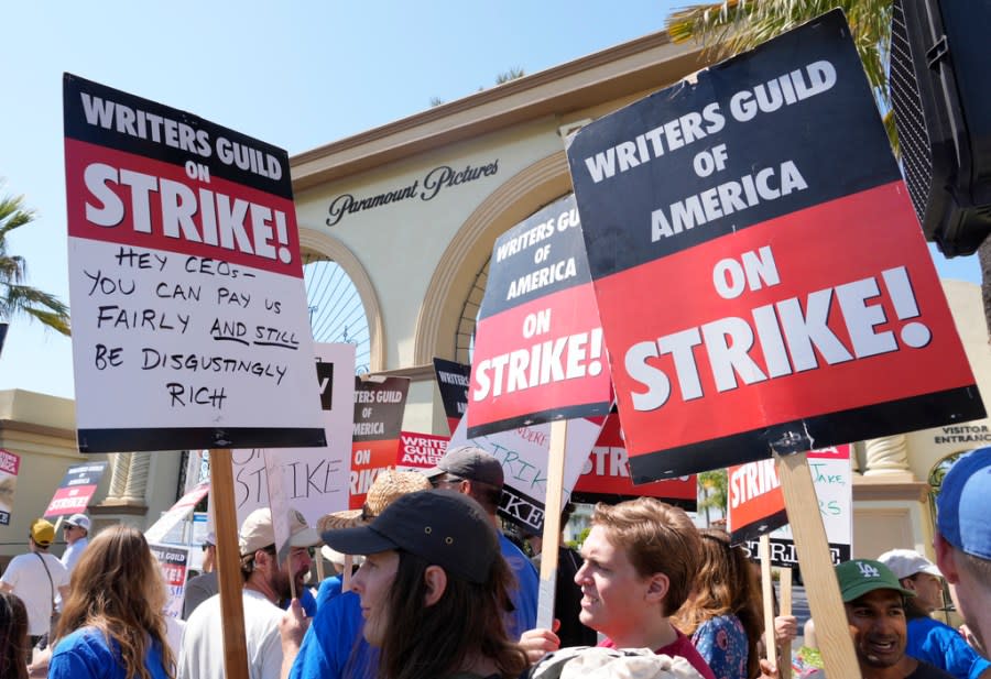 FILE - Striking Writers Guild members hold signs during a rally in front of Paramount Pictures studio in Los Angeles on May 17, 2023. Hollywood actors may be on the verge of joining screenwriters in what would be the first two-union strike in the industry in more than six decades. (AP Photo/Chris Pizzello, File)