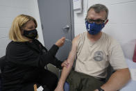 Veronica Pfister, R.N., administers a Johnson and Johnson Covid-19 vaccine to race fan Joshua Knight, of Noblesville, Ind., at the Indianapolis Motor Speedway before the Indianapolis 500 auto race in Indianapolis, Sunday, May 30, 2021. (AP Photo/Paul Sancya)