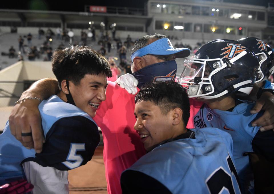 Carroll High School head football coach Juan Rodriguez, center, celebrates his first win with Carroll as head coach, Thursday, Oct. 15, 2020, at Buc Stadium. Carroll broke its 25-game losing streak.