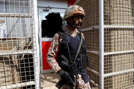 A paramilitary soldier stands guard outside the entrance with a broken widow, after an attack by suicide bombers on the Chinese consulate, in Karachi, Pakistan November 23, 2018. REUTERS/Akhtar Soomro