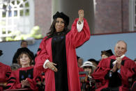 FILE - In this May 29, 2014 file photo, singer Aretha Franklin waves as she receives an honorary Doctor of Arts degree as Chilean author Isabel Allende, left, and former Mayor of New York City Michael Bloomberg, right, look on during Harvard commencement ceremonies in Cambridge, Mass. Franklin died Thursday, Aug. 16, 2018 at her home in Detroit. She was 76. (AP Photo/Steven Senne, File)