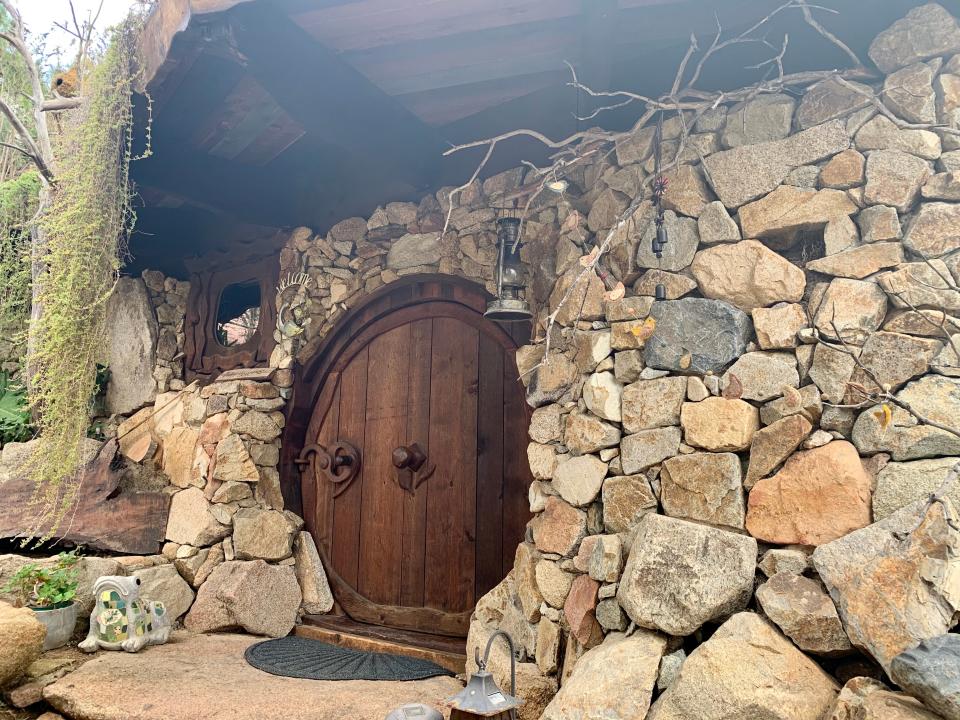 Fiona Chandra, round door entrance to hobbit house, "I paid $412 to Stay in a Hobbit House."
