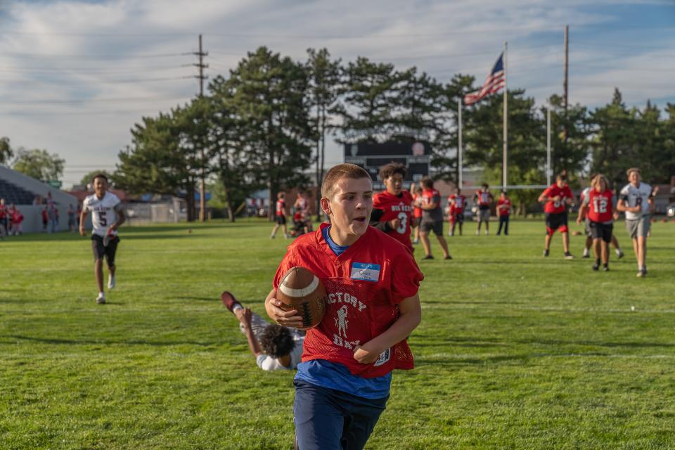 A boy scores a touchdown during Victory Day at Memorial Stadium in Port Huron on Friday, Aug. 12, 2022.