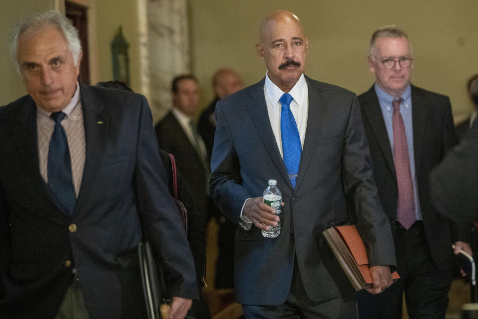 Ted Wells, Jr., center, the lead attorney for Exxon, leaves Manhattan Supreme court after opening arguments in a lawsuit against Exxon, Tuesday, Oct. 22, 2019, in New York. The lawsuit brought on by New York's attorney general, claims the Texas energy giant kept two sets of books — one accounting for climate change regulations and the other underestimating the costs — to make the company appear more valuable to investors. (AP Photo/Mary Altaffer)