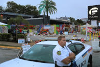 <p>A police car stands guard as people visit the memorial to the victims of the mass shooting setup around the Pulse gay nightclub one year after the shooting on June 12, 2017 in Orlando, Florida. (Joe Raedle/Getty Images) </p>