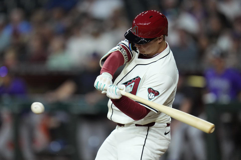 Arizona Diamondbacks' Joc Pederson starts his swing for a double against the Colorado Rockies during the first inning of a baseball game Friday, March 29, 2024, in Phoenix. (AP Photo/Ross D. Franklin)