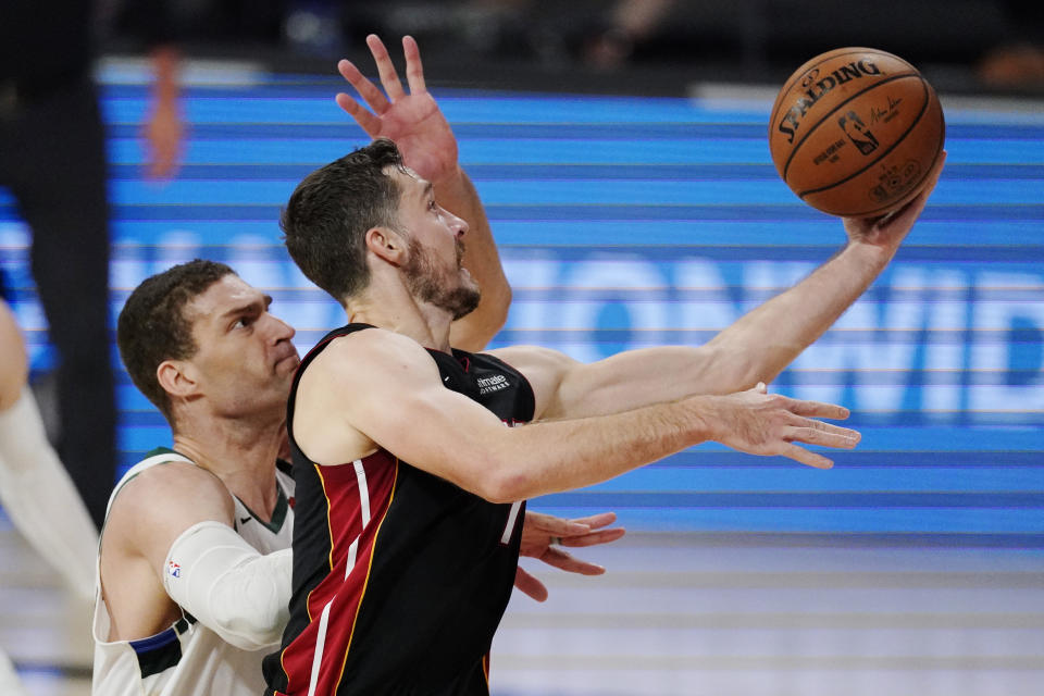 Miami Heat's Goran Dragic (7) shoots in front of Milwaukee Bucks' Brook Lopez, left, in the first half of an NBA conference semifinal playoff basketball game Friday, Sept. 4, 2020, in Lake Buena Vista, Fla. (AP Photo/Mark J. Terrill)