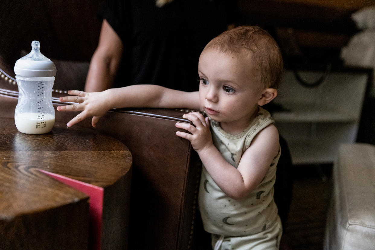 Jack, Lisa Davis' 14-month-old-son, reaches for a bottle of formula at a hotel room in Austin. (Ilana Panich-Linsman for NBC News)