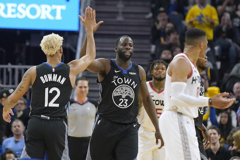 Golden State Warriors forward Draymond Green (23) is congratulated by Ky Bowman (12) after scoring against the Houston Rockets during the first half of an NBA basketball game in San Francisco, Wednesday, Dec. 25, 2019. (AP Photo/Tony Avelar)