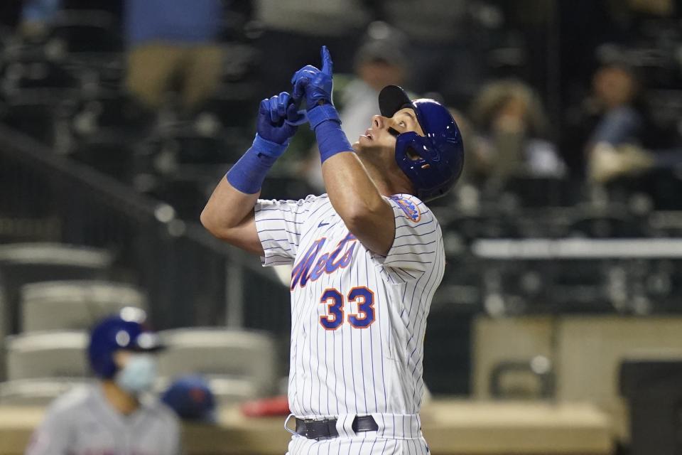 New York Mets' James McCann (33) gestures as he reaches home plate after hitting a two-run home run during the eighth inning of a baseball game against the Philadelphia Phillies Wednesday, April 14, 2021, in New York. (AP Photo/Frank Franklin II)