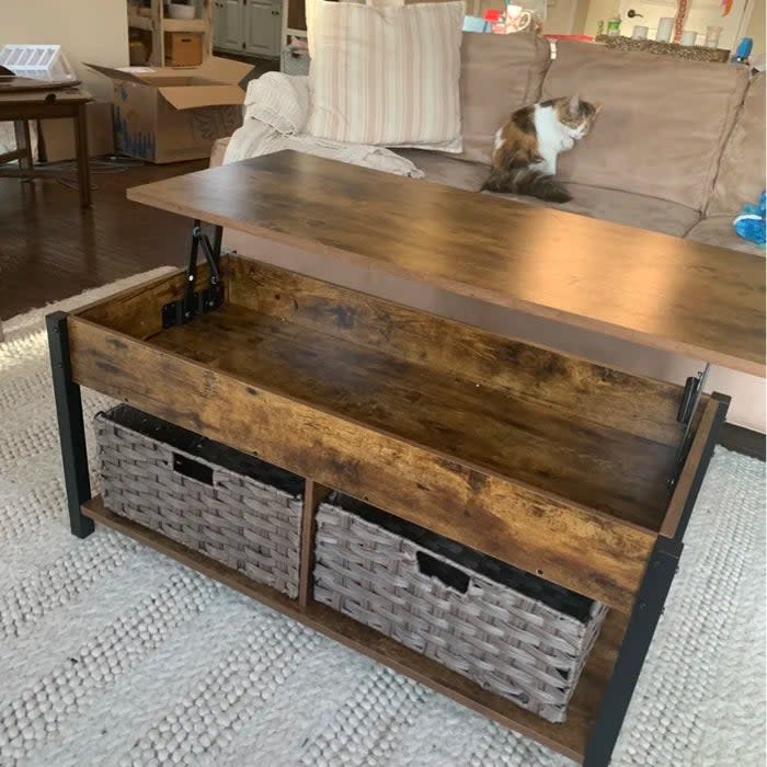 Same reviewer's photo of the coffee table with the top lifted to reveal additional storage space