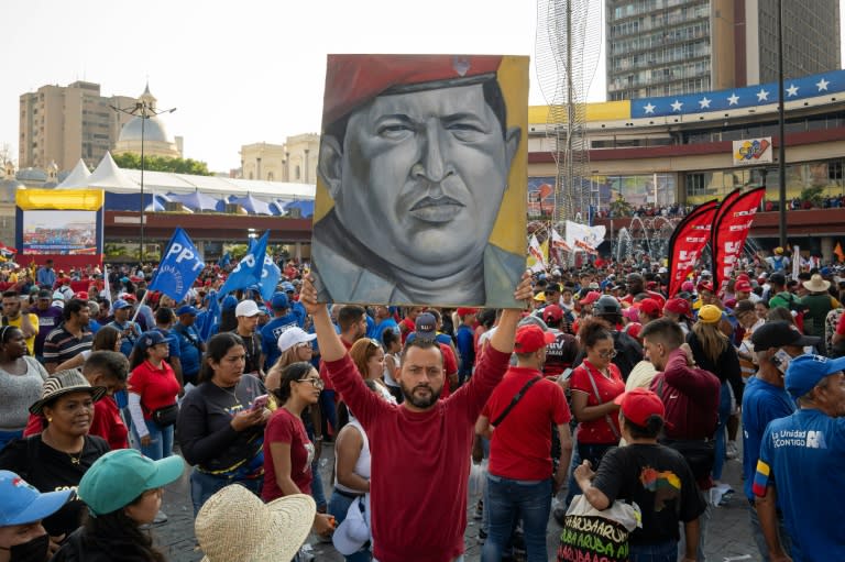 (ARCHIVO) Un simpatizante de Nicolas Maduro sostiene un cuadro con la imagen de Hugo Chavez delante del Consejo Nacional Electoral (CNE) el 25 de marzo de 2024. (Ronald PEÑA)