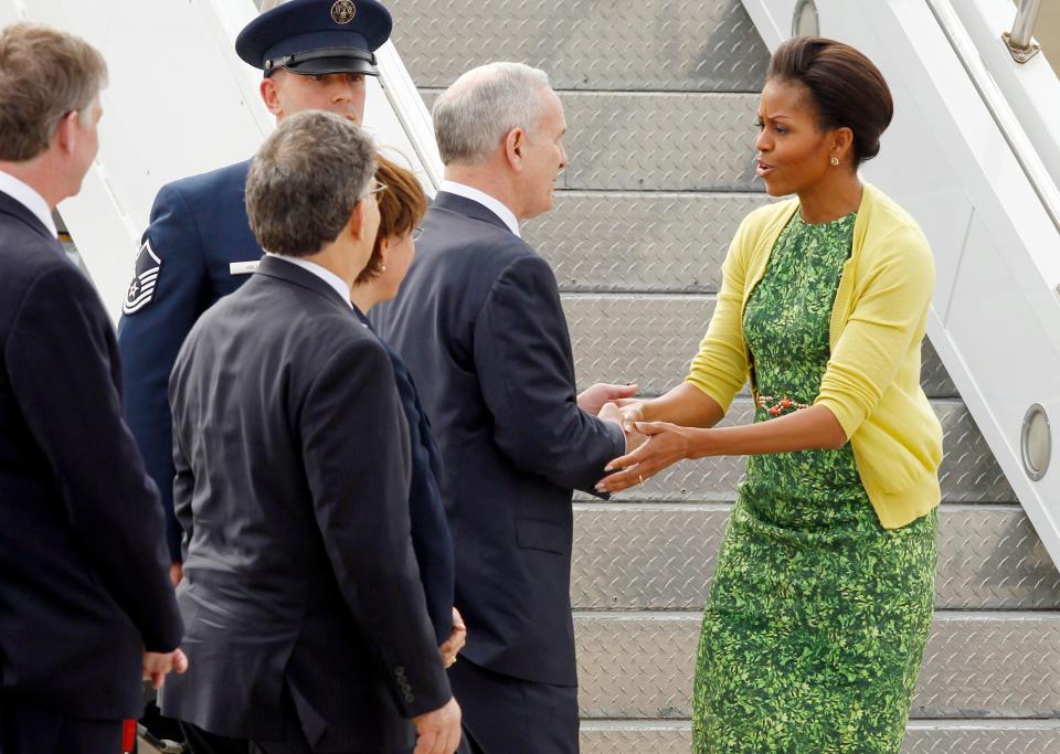 Michelle Obama visits the Minnesota Air National Guard base wearing a green dress.
