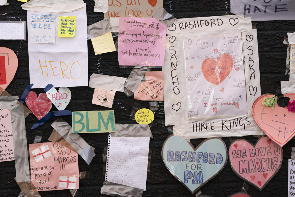 A view of the messages of support left on a mural of Manchester United striker and England player Marcus Rashford, on the wall of the Coffee House Cafe on Copson Street, in Withington, Manchester, England, Tuesday July 13, 2021. The mural was defaced with graffiti in the wake of England losing the Euro 2020 soccer championship final match to Italy. (AP Photo/Jon Super)