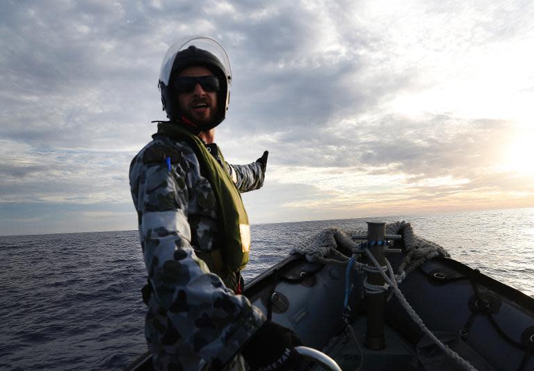 Able Seaman Boatswain's Mate Cameron Grant directs a Rigid Hull Inflatable Boat from HMAS Perth while searching for debris from missing Malaysia Airlines flight MH370 in the southern Indian Ocean, April 7, 2014