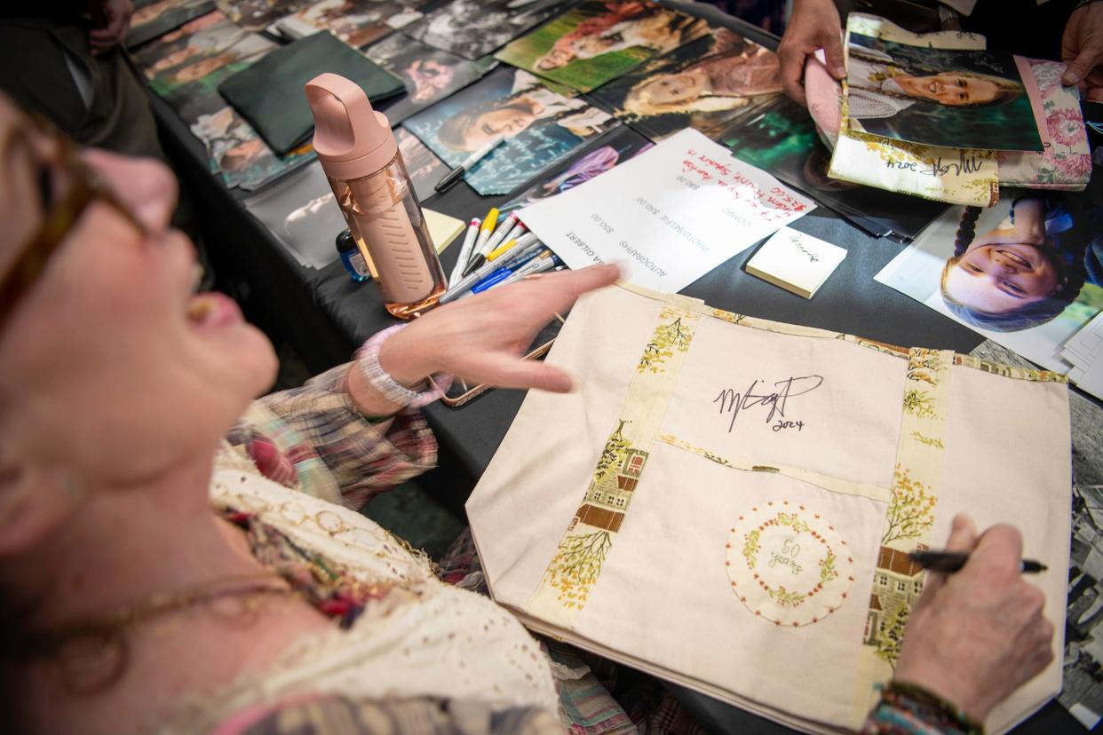 Melissa Gilbert signs a commemorative 50th anniversary tote bag from Modern Prairie for a fan.