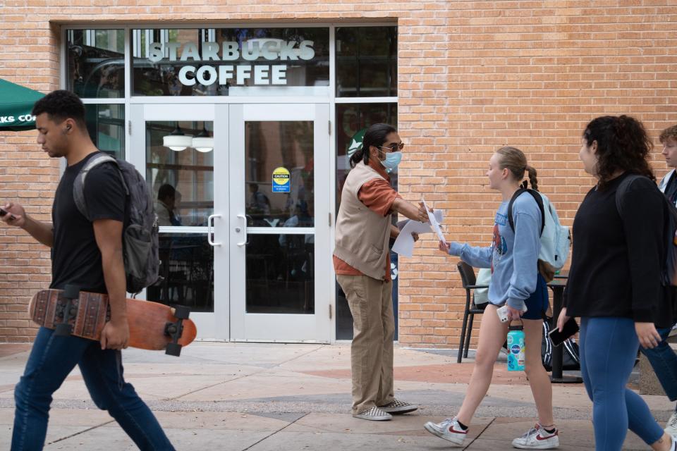 Domingo Montez (center, ASU student) hands out Starbucks boycott fliers in front of the Starbucks at ASU Tempe Memorial Union on Nov. 16, 2023.